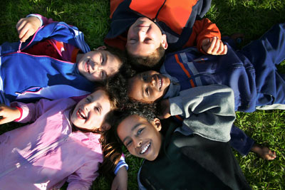 A photo of several young men and woman laying down in a circle, their heads in the centre.